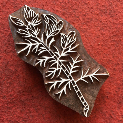 Wooden stamp with leaf design on a red background